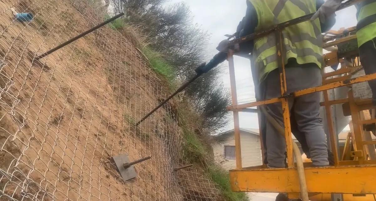 Perno autoperforante R25 instalado con su placa de apoyo metálica en talud