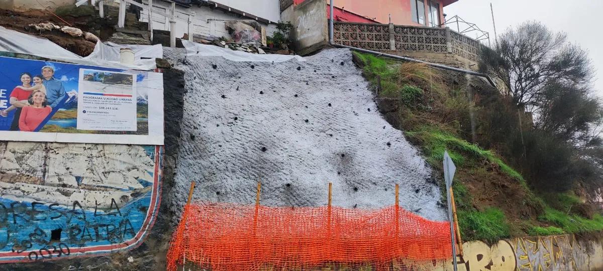 Talud de tierra estabilizado completamente con una capa sólida de shotcrete gris